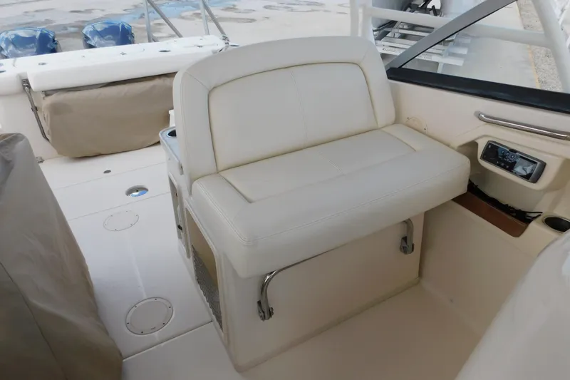 Slide: The Image of 2015 Grady-White Freedom 307 boat interior with white seating and control panel. - 26