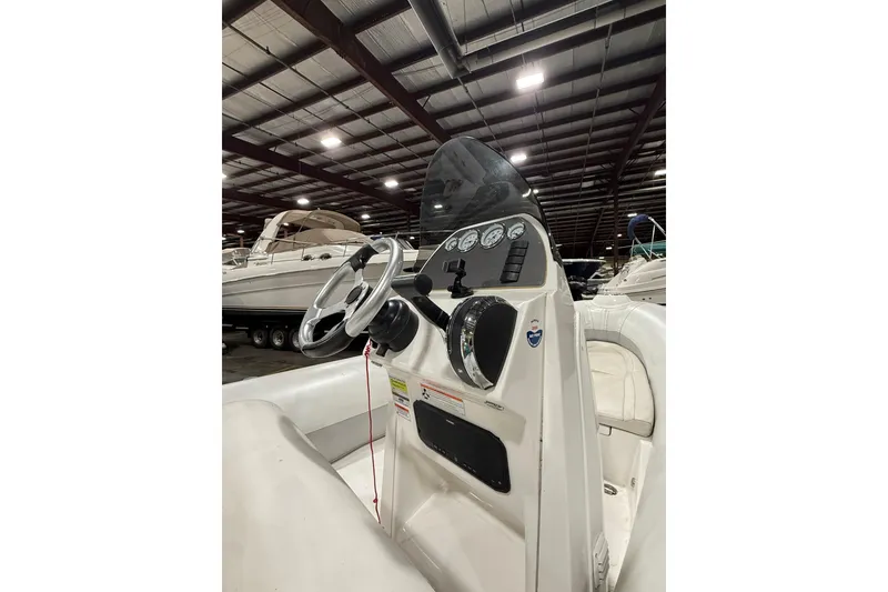 Slide: The Image of 2013 Mercury 560 boat dashboard in a warehouse with other boats. - 10