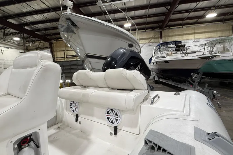 Slide: The Image of 2013 Mercury 560 boat in indoor storage, featuring white seating and visible engine. - 11