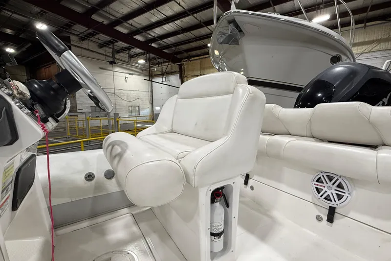 Slide: The Image of Interior of a 2013 Mercury 560 boat with white seating and steering wheel. - 12