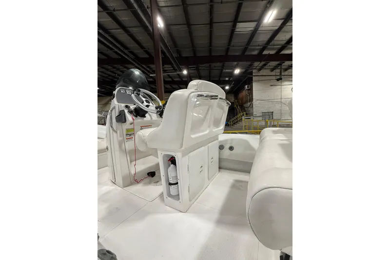 Slide: The Image of 2013 Mercury 560 boat interior with steering console and seating in a warehouse. - 4