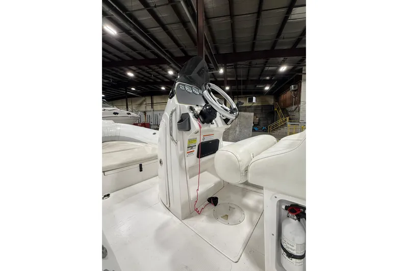 Slide: The Image of 2013 Mercury 560 boat interior with steering console and seating in a warehouse. - 5