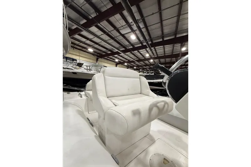 Slide: The Image of White captain's chair on a 2013 Mercury 560 boat in a warehouse setting. - 9