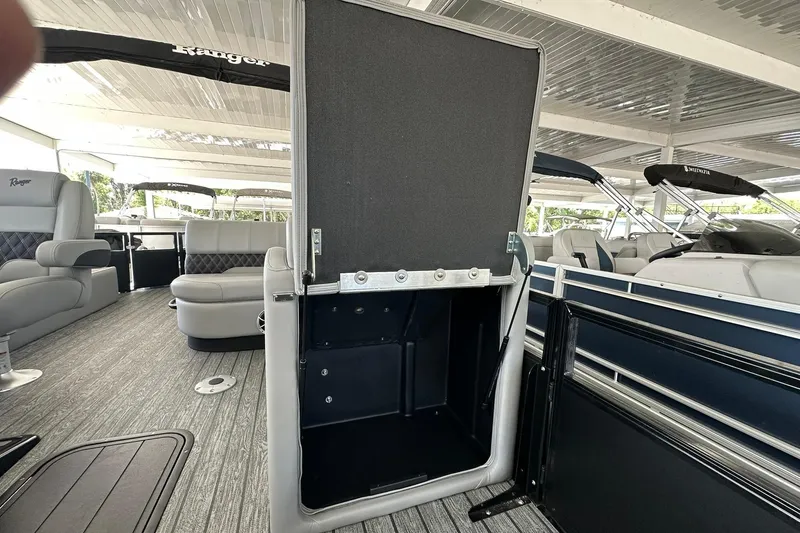 Slide: The Image of 2026 Ranger Reata 223FC boat interior with open storage compartment and seating area. - 16