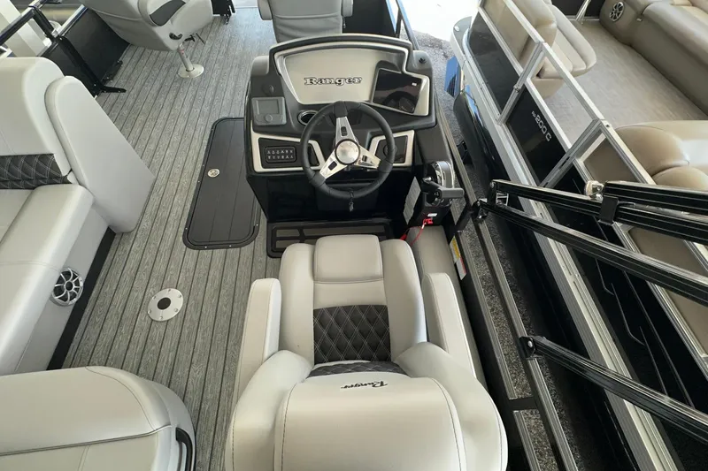 Slide: The Image of Interior view of 2026 Ranger Reata 223FC boat, featuring sleek seating and modern steering console. - 17