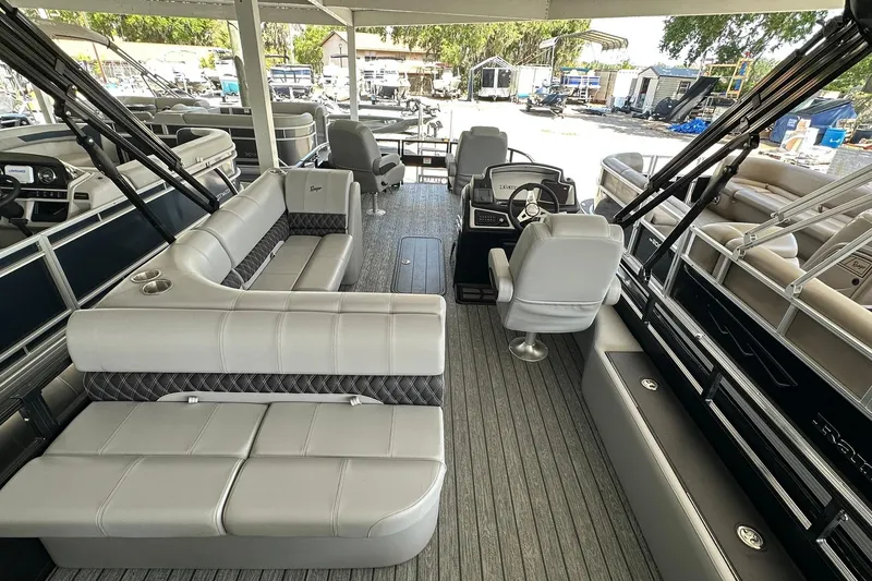 Slide: The Image of 2026 Ranger Reata 223FC pontoon boat interior with plush seating and modern helm. - 27