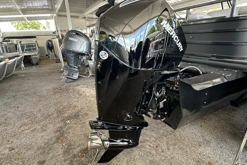 Slide: The Image of 2026 Ranger Reata 223FC boat with Mercury and Yamaha outboard motors in a covered storage area. - 37