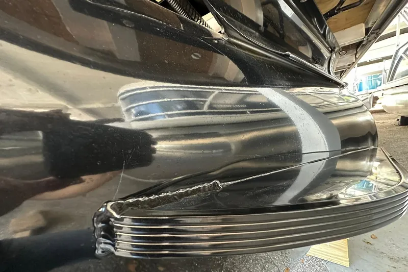 Slide: The Image of 2026 Ranger Reata 223FC boat with visible hull damage in a storage area. - 5