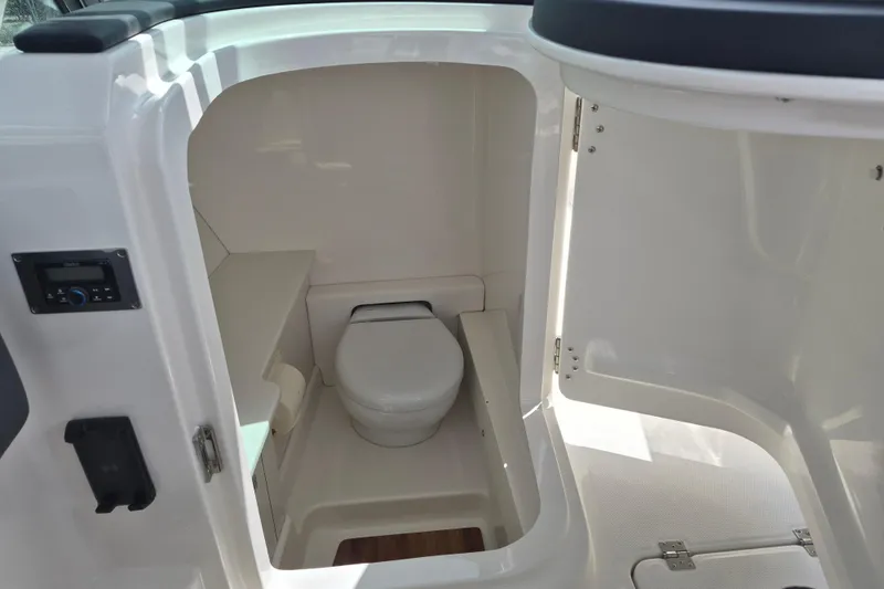 Slide: The Image of 2026 Robalo R277 Dual Console boat interior with compact marine toilet. - 10