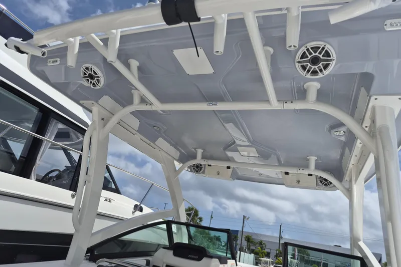 Slide: The Image of 2026 Robalo R277 Dual Console boat with speakers and canopy, viewed from below. - 14