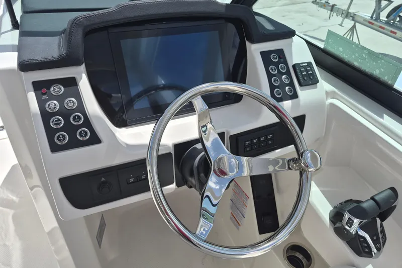 Slide: The Image of 2026 Robalo R277 Dual Console boat dashboard with steering wheel and control panel. - 5