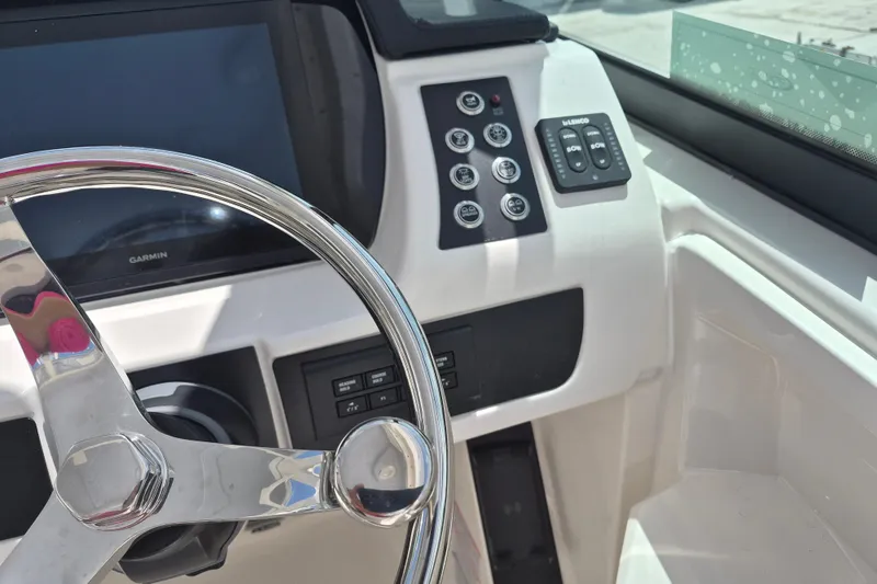 Slide: The Image of 2026 Robalo R277 Dual Console boat dashboard with steering wheel and control panel. - 7