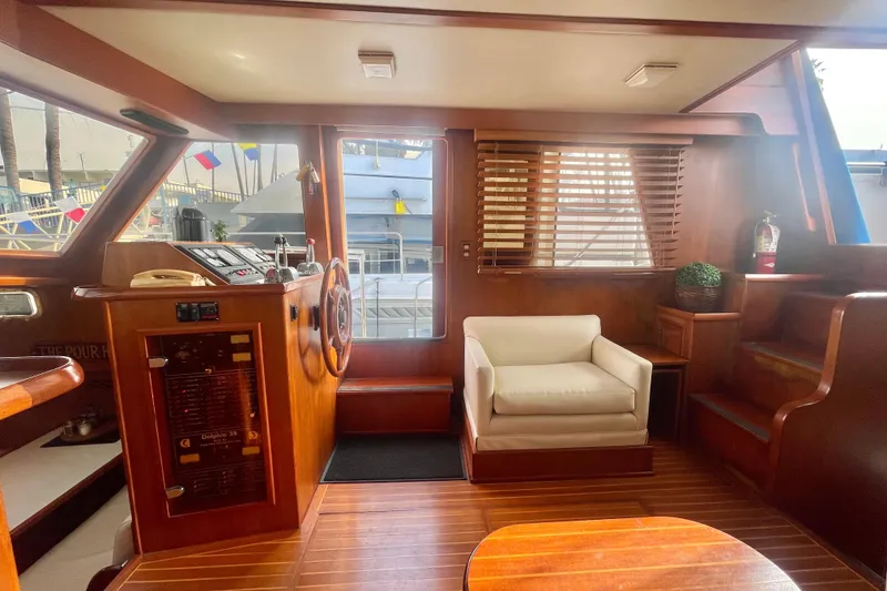 Slide: The Image of 1986 Tung Hwa aft cabin interior with wooden decor, steering wheel, and white armchair. - 16