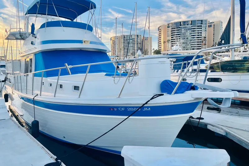 Slide: The Image of 1986 Tung Hwa aft cabin boat docked at marina with modern buildings in background. - 2
