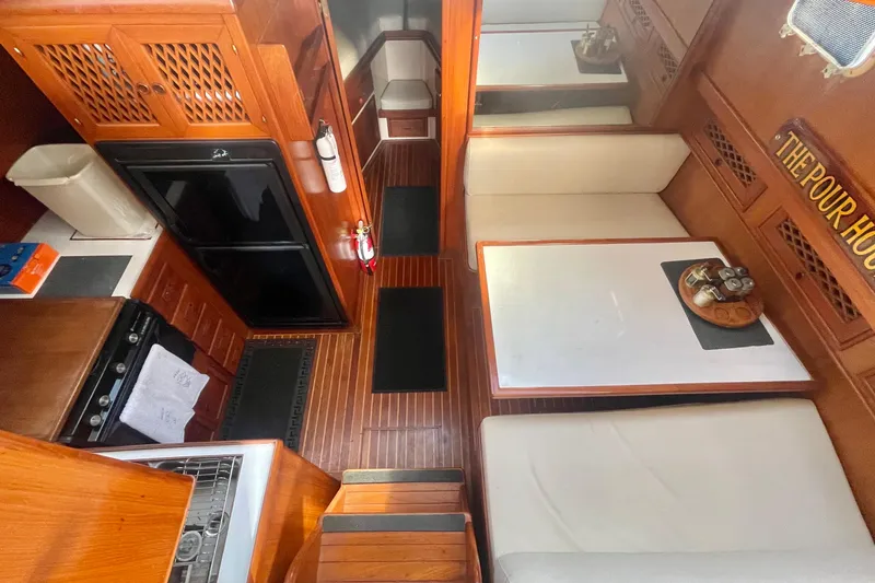 Slide: The Image of 1986 Tung Hwa aft cabin interior with wood finish, kitchen, and seating area. - 21