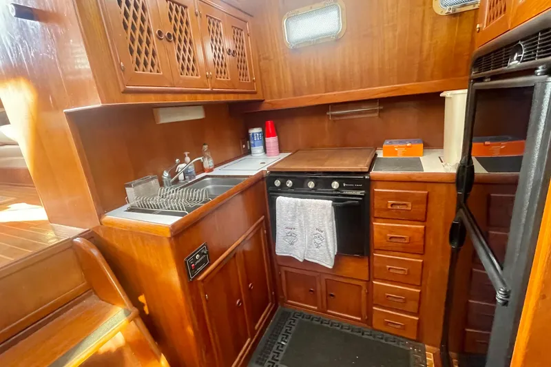 Slide: The Image of 1986 Tung Hwa aft cabin kitchen with wooden cabinetry, sink, and stove. - 24