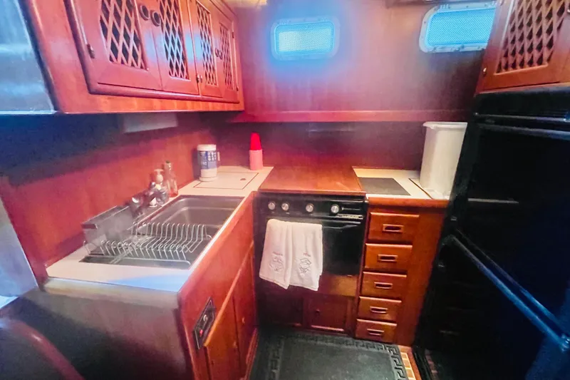 Slide: The Image of 1986 Tung Hwa aft cabin kitchen with wooden cabinetry, sink, stove, and storage drawers. - 31