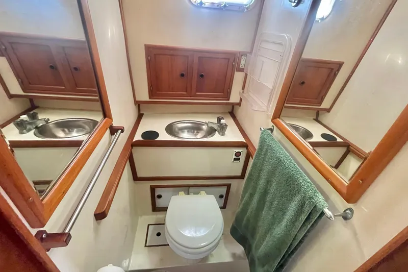 Slide: The Image of 1986 Tung Hwa aft cabin bathroom with sink, toilet, mirrors, and wooden cabinets. - 42