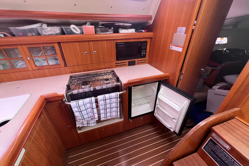 Slide: The Image of 2006 Hunter 38 yacht kitchen with stove, microwave, and open fridge. - 10