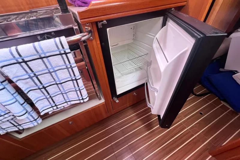 Slide: The Image of Open refrigerator in 2006 Hunter 38 yacht kitchen with wooden flooring. - 11
