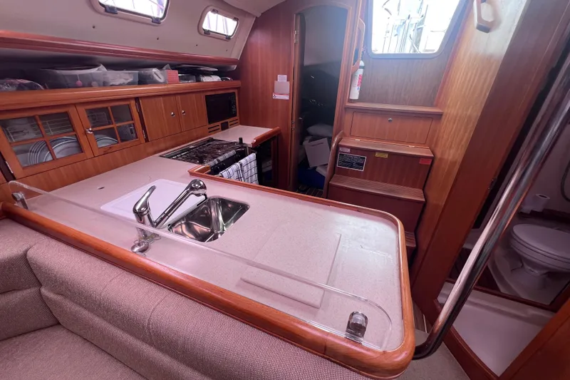 Slide: The Image of Interior of 2006 Hunter 38 sailboat featuring kitchen and seating area. - 13
