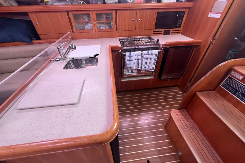 Slide: The Image of Interior of 2006 Hunter 38 sailboat galley with sink, stove, and wooden cabinetry. - 14