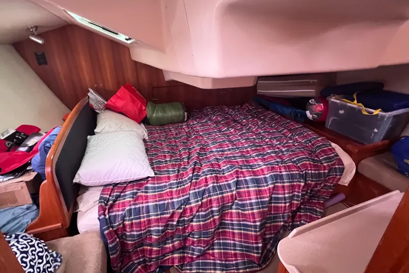 Slide: The Image of Cozy cabin interior of 2006 Hunter 38 sailboat with plaid bedding and storage. - 16