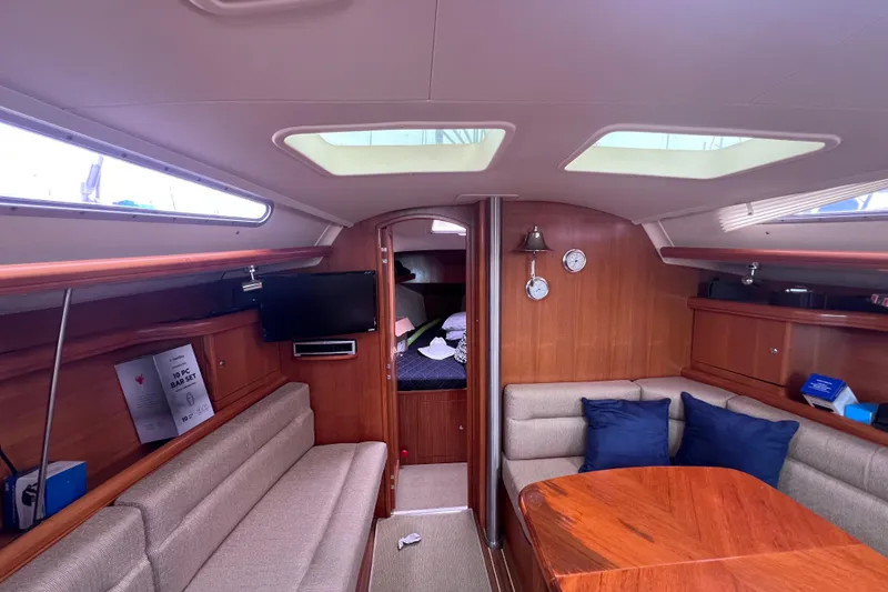 Slide: The Image of Interior of a 2006 Hunter 38 sailboat with cozy seating and wooden finishes. - 17