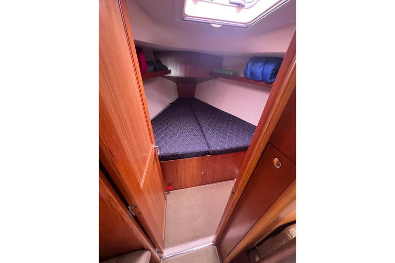 Slide: The Image of Cozy cabin interior of 2006 Hunter 38 sailboat with wooden finish and bedding. - 19