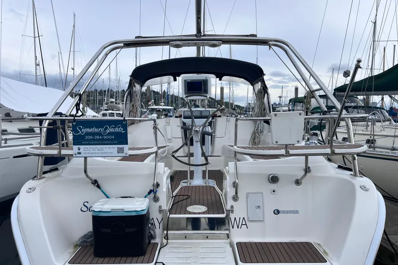 Slide: The Image of 2006 Hunter 38 sailboat at marina, featuring cockpit and steering wheel. - 2