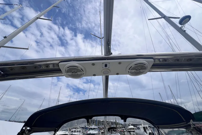 Slide: The Image of Sailboat cockpit view with speakers, Hunter 38 model, 2006, under a partly cloudy sky. - 6