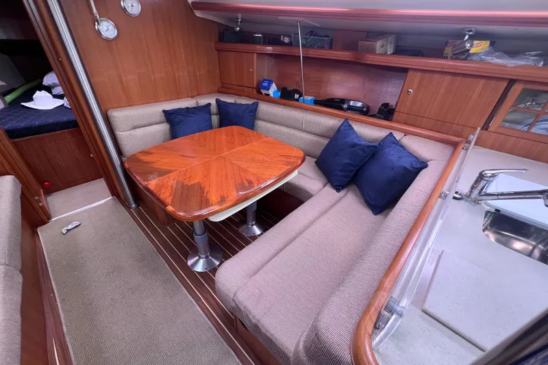 Slide: The Image of Cozy interior of 2006 Hunter 38 sailboat with wooden table and cushioned seating. - 7