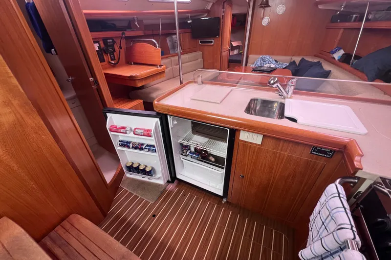 Slide: The Image of Interior of a 2006 Hunter 38 sailboat featuring a compact kitchen with open fridge. - 9
