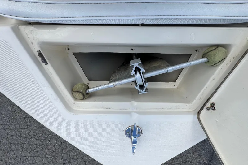 Slide: The Image of Storage compartment of a 1996 Scout 202 Dorado boat with a metal rod and tennis balls. - 15