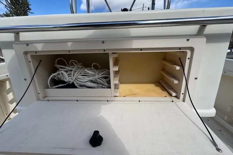 Slide: The Image of Storage compartment on a 1996 Scout 202 Dorado boat with rope and shelves. - 19
