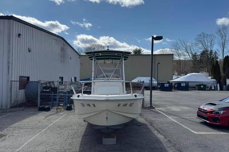 Slide: The Image of 1996 Scout 202 Dorado boat parked outdoors near industrial buildings under a clear sky. - 3