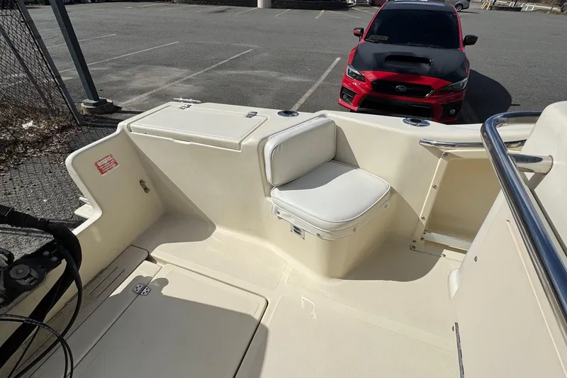 Slide: The Image of 1996 Scout 202 Dorado boat interior with seating, parked near a red car. - 8