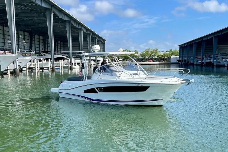 Slide: The Image of 2019 Jeanneau Leader 9.0 WA boat docked in a marina under a clear blue sky. - 1