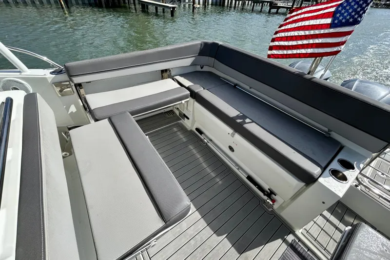 Slide: The Image of 2019 Jeanneau Leader 9.0 WA boat interior with seating and American flag. - 12