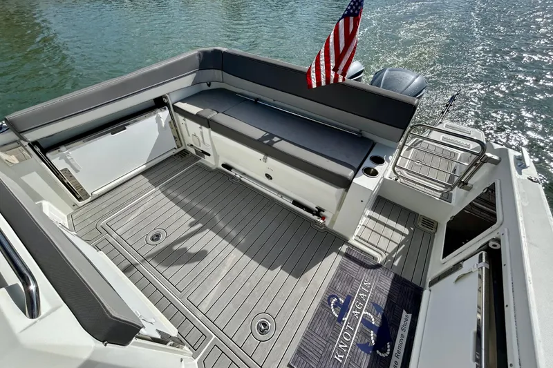 Slide: The Image of 2019 Jeanneau Leader 9.0 WA boat deck with seating and American flag. - 13