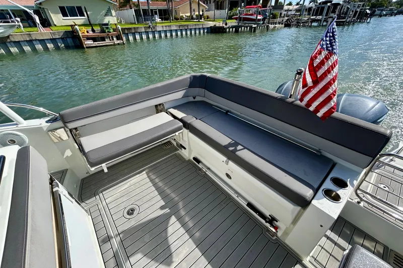 Slide: The Image of 2019 Jeanneau Leader 9.0 WA boat with seating area and American flag on deck. - 14