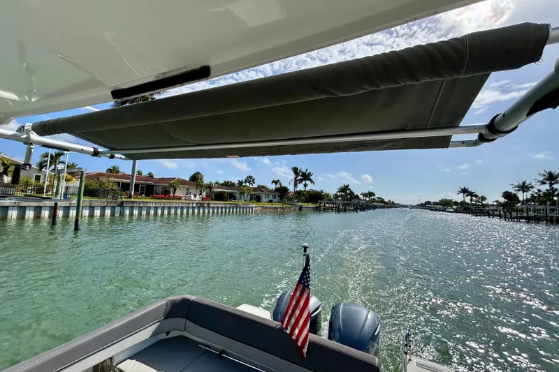 Slide: The Image of 2019 Jeanneau Leader 9.0 WA cruising on a sunny waterway with American flag. - 19