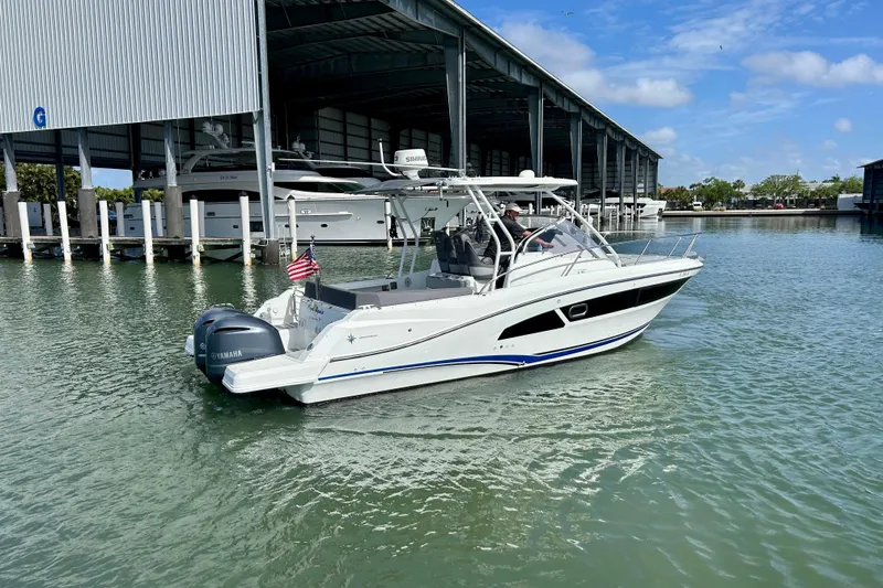 Slide: The Image of 2019 Jeanneau Leader 9.0 WA boat cruising near a marina with Yamaha engines. - 2