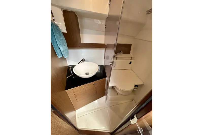 Slide: The Image of 2019 Jeanneau Leader 9.0 WA boat bathroom with sink, toilet, and wooden cabinetry. - 28