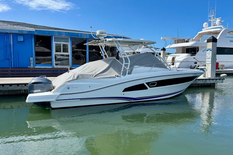 Slide: The Image of 2019 Jeanneau Leader 9.0 WA boat docked with Yamaha engine, blue building background. - 4
