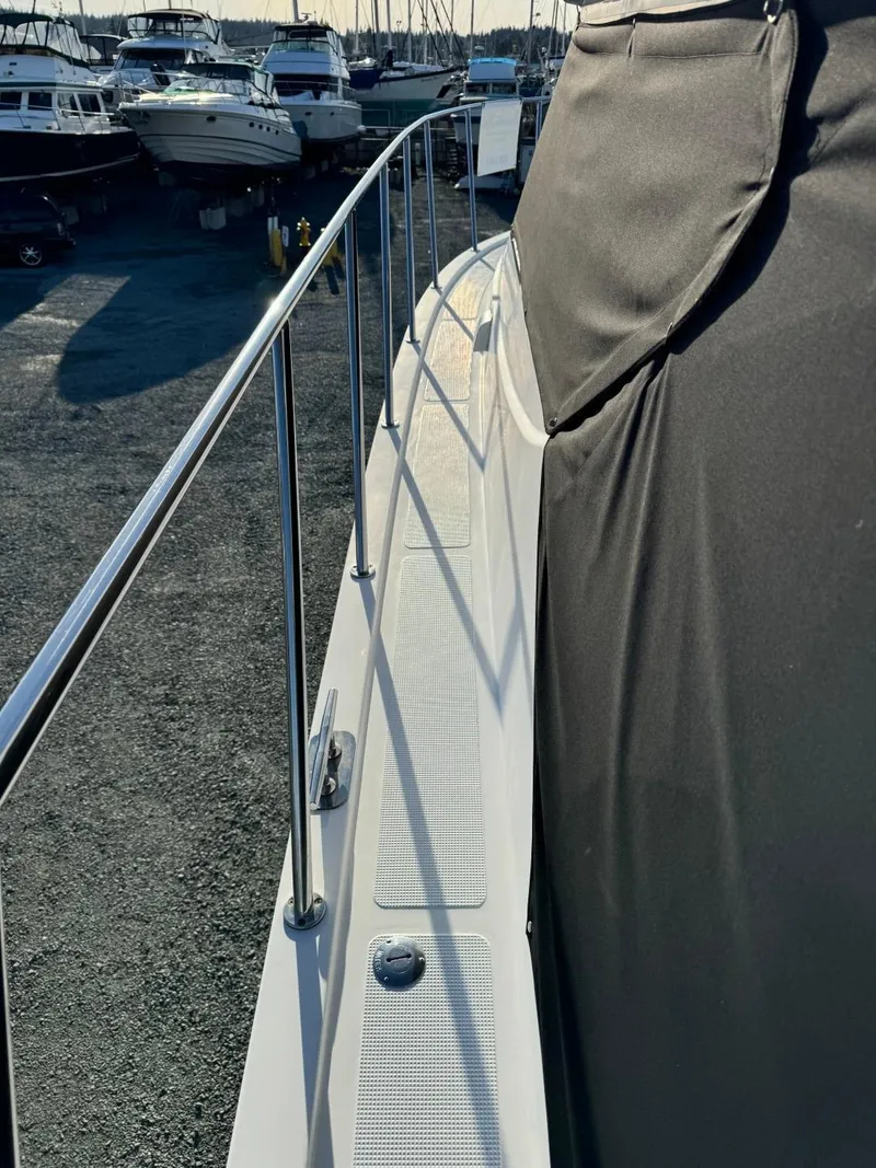 Slide: The Image of 2004 Ocean Alexander 42 yacht deck with railing, docked among other boats. - 38