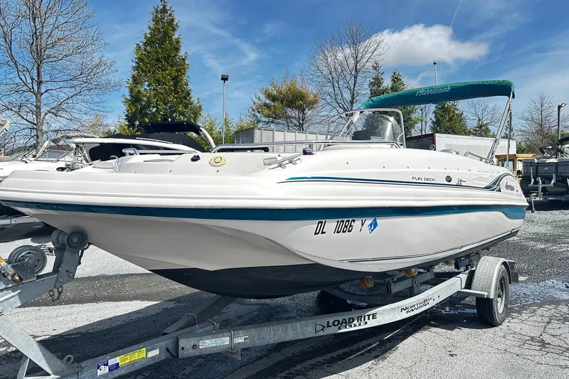 The Image of 2003 Godfrey Hurricane GS 211 boat on trailer, parked outdoors under clear sky. - 0