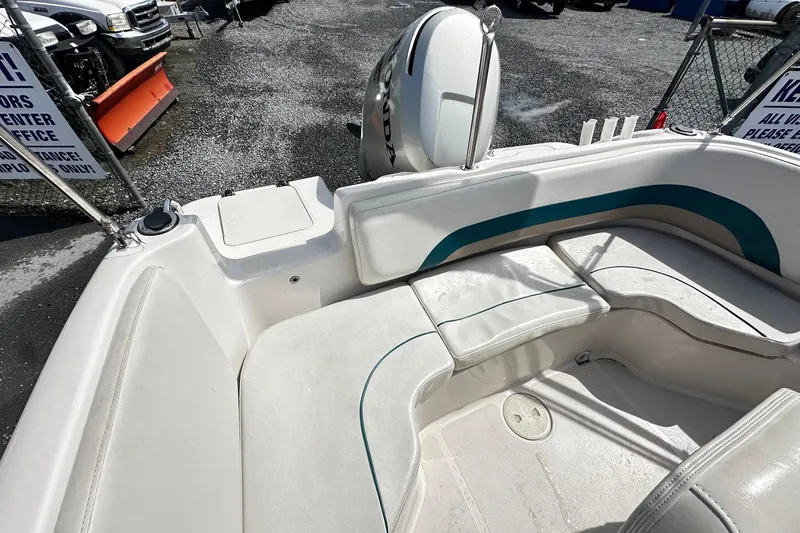 Slide: The Image of 2003 Godfrey Hurricane GS 211 boat interior with seating and motor, parked outdoors. - 11