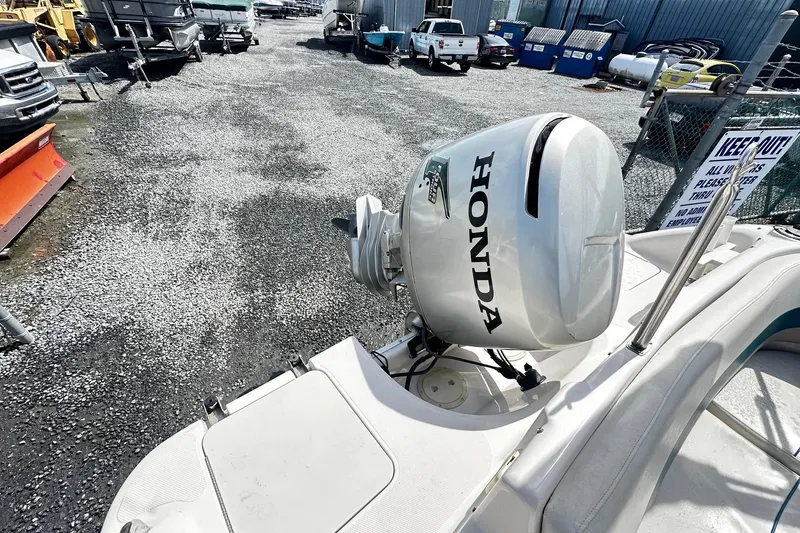 Slide: The Image of 2003 Godfrey Hurricane GS 211 boat with Honda outboard motor in a gravel lot. - 12