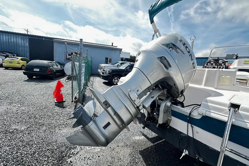 Slide: The Image of 2003 Godfrey Hurricane GS 211 boat with Honda outboard motor in a parking lot. - 3